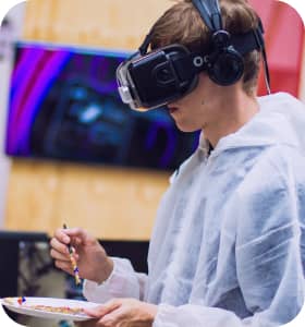 a boy wearing vr glasses with a paint palette in his hands