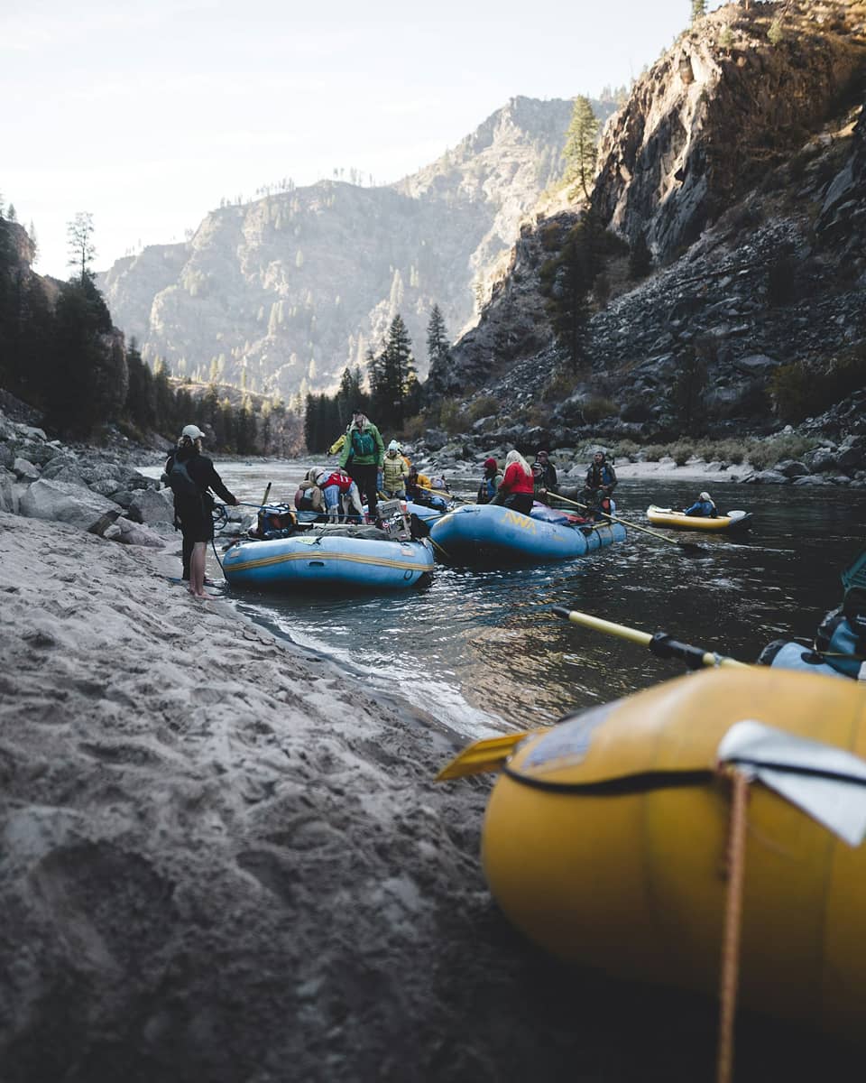 people on rafting boats by the end of a river